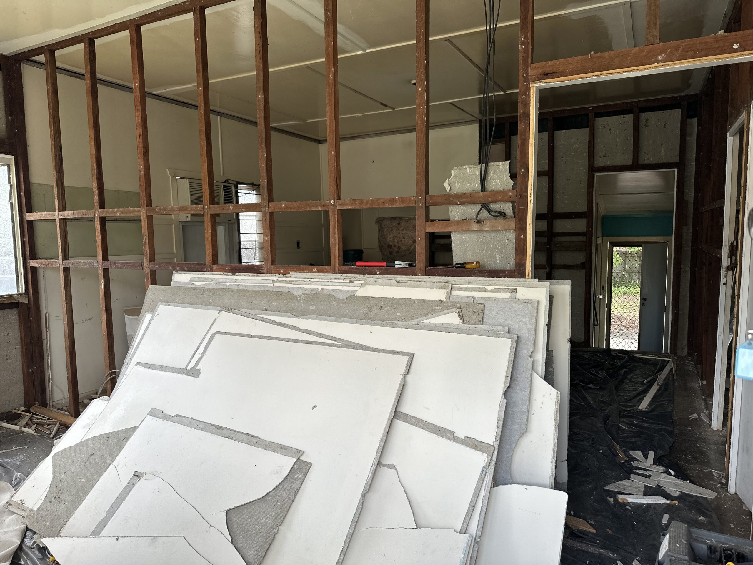 Bonded asbestos cement flat sheeting installed as internal wall lining in an old Queenslander